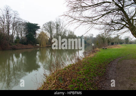 Die Themse und Runnymede Wiese / Flut schlicht an einem kalten feuchten grauen Wintertag / Wintertag, mit schlammigen Pfad / Fuß Weg. Runnymede, Surrey. VEREINIGTES KÖNIGREICH. Stockfoto