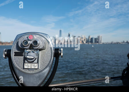 Turm-Viewer-Fernglas im Vordergrund unscharf New Yorker Skyline im Hintergrund mit Blick auf Hudson River und den Hafen von New York an einem hellen sonnigen d Stockfoto