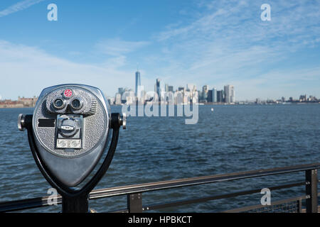 Turm-Viewer Teleskop untere Manhattan Skyline von Liberty Island zu betrachten. Geländer und Fernglas auf einem Stativ für Touristen in New York City fr anzeigen Stockfoto