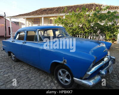 Klassische amerikanische blaues Auto geparkt mit alten kolonialen Gebäuden im Hintergrund auf einer gepflasterten Straße in Trinidad, Kuba Stockfoto