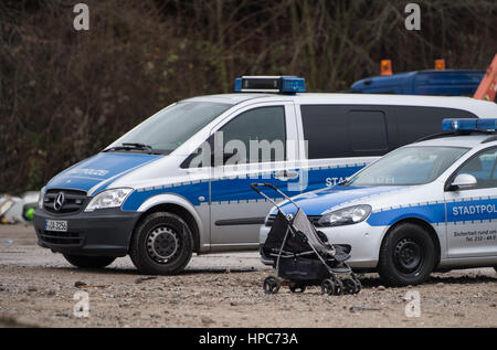 Einen leeren Kinderwagen kann zwei Polizeifahrzeuge auf einer Gewerbeimmobilie im Gutleutviertel Viertel am Stadtrand von Frankfurt Am Main, Deutschland, 21. Februar 2017 gesehen werden. Die Handbuilt Hütten der Bewohner des Anwesens wurden abgerissen. Mehrere Dutzend Rumänen lebten in den Holzschuppen. Foto: Susann Prautsch/dpa Stockfoto