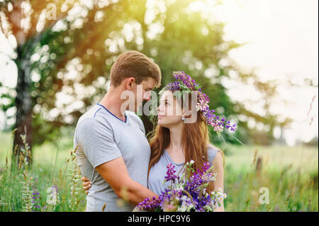 schöne junge Paar im Frühlingsgarten mit einem Bouquet von Wildblumen Stockfoto