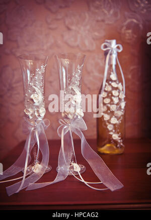 Zwei Hochzeit Gläser und eine Flasche Champagner auf dem Tisch Stockfoto