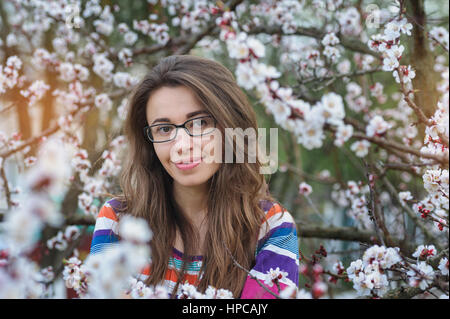 lächelnde junge Frau in den blühenden Frühlingsgarten Stockfoto