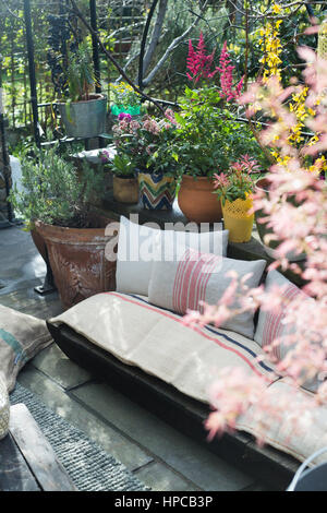 Einen Platz auf einem sonnigen Urban Garden Patio mit Pflanzen im Sommer umgeben Stockfoto