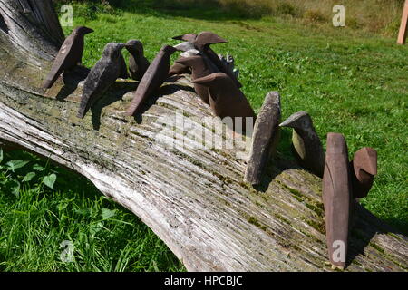 Geschnitzte Vögel Skulptur, auf einen umgestürzten Baum, in Westhay Moor National Nature Reserve Stockfoto