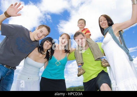 Model Release, Junge, Froehliche Leute Unter Blauem Wolkenhimmel - junge, glückliche Menschen unter blau, bewölkten Himmel Stockfoto