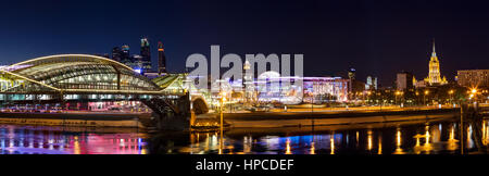 Nacht-Winterpanorama von der Moskwa-Ufer: Fußgängerbrücke Bogdan Khmelnitsky, Kiyevskaya Bahnhof, Stadt Moskau, Radisson Slavyans Stockfoto