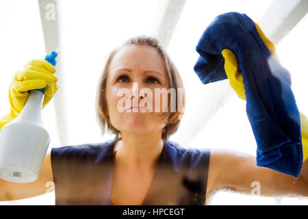 Model Release, Junge Putzfrauen Beim Fensterputzen - Frau reinigt das Fenster Stockfoto