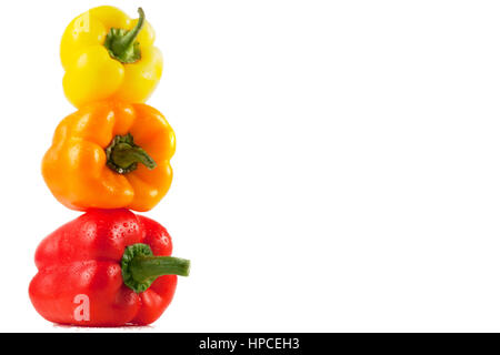 Drei saftige, leckere Bellpeppers, isoliert auf weißem Hintergrund. Verlegung auf einander machen Pyramide. Stockfoto