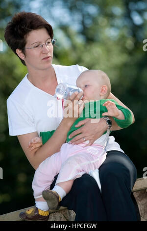 Gibt Kleinkind Flaeschchen Mutter - Mutter gibt Baby Babyflasche Stockfoto