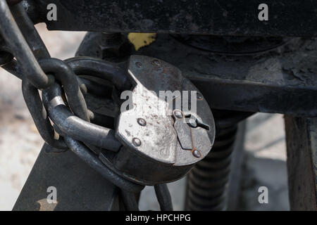 Das alte Schloss durch eine Kette wiegt auf eine Spalte mit einem Eisen Fechten. Stockfoto