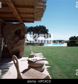 Garten Park von einem italienischen Luxus Villa in Port Cervo, Sardinien mit zwei Stühlen, einem kleinen Tisch und zwei Gläser Wasser mit Blick auf einen wunderschönen Pool Stockfoto