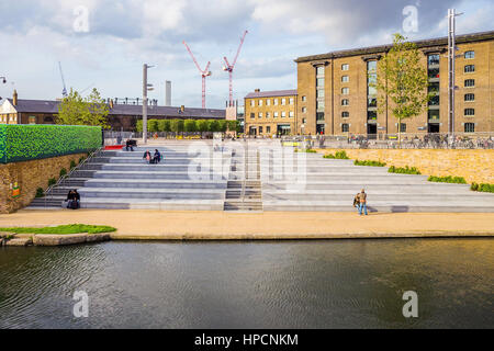 LONDON - Oktober 17: Menschen sitzen am Kanal in Kings Cross außerhalb des Central Saint Martins Universitätscampus. Touristen und Studenten übergeben oft Stockfoto