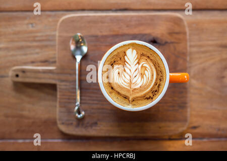 Kaffee Cappuccino-Tasse serviert am Holzbrett Draufsicht. Geringe Schärfentiefe Stockfoto
