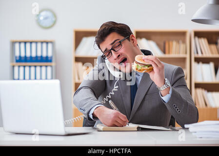 Hungrige lustige Geschäftsmann Essen Junk-Food-sandwich Stockfoto