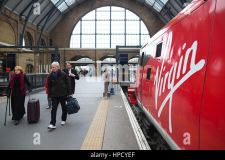 Pendler, die eine Jungfrau Ostküste Zug am Kings Cross mainline-Station in London, England, UK Stockfoto