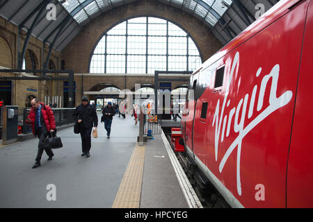 Pendler, die eine Jungfrau Ostküste Zug am Kings Cross mainline-Station in London, England, UK Stockfoto