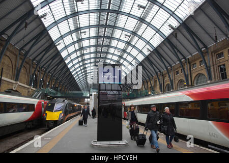 Pendler, die eine Jungfrau Ostküste Zug am Kings Cross mainline-Station in London, England, UK Stockfoto