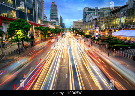 Belebte Straße in der Stadt in der Abenddämmerung, voll von Auto helle Streifen; dynamische blaue Stunde geschossen mit langer Belichtung Motion Blur-Effekt Stockfoto