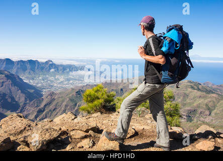 Ältere männliche Wanderer auf Alta Vista Berg auf Gran Canaria mit La Aldea de San Nicolas Dorf in Ferne. Kanarischen Inseln. Spanien Stockfoto