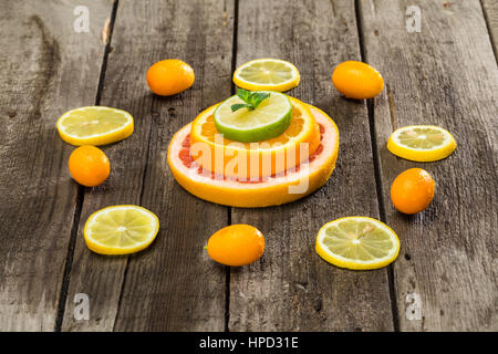 Vielzahl von Zitrusfrüchten Scheiben und Kumquats auf Holztisch Stockfoto
