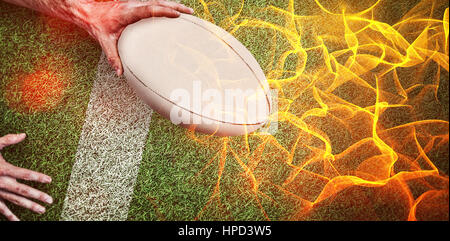Abstrakte orange glühenden schwarzen Hintergrund gegen zusammengesetztes Bild des zugeschnittenen Bildes eines Mannes mit Rugby-ball Stockfoto