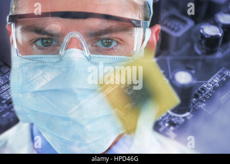 Arzt in Schutzbrille und chirurgische Maske mit elektronischen Chip gegen Sperre auf Leiterplatten Stockfoto