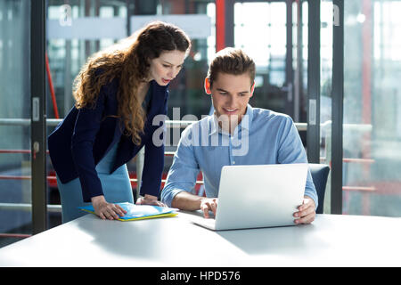 Geschäftsleute, die Diskussion über Laptop im Büro Stockfoto