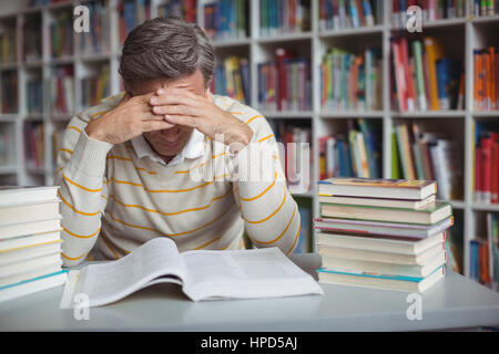 Gespannten Lehrer studieren in Bibliothek in der Schule Stockfoto