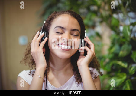 Nahaufnahme des weiblichen executive Musik hören über Kopfhörer im Büro Stockfoto