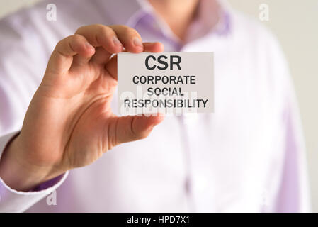 Closeup auf Geschäftsmann hielt eine Karte mit Text CSR-Corporate Social Responsibility, Firmen-Konzept-Image mit soft-Fokus-Hintergrund Stockfoto