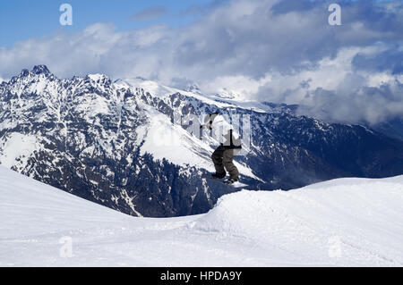 Snowboarder springen im Snowpark im Skigebiet auf Wintertag. Kaukasus-Gebirge, Region Dombay. Stockfoto