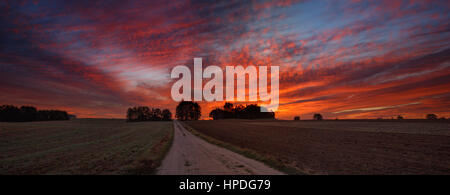 Straße gehen Sonnenaufgang mit wunderschönen orange launisch bewölktem Himmel Stockfoto