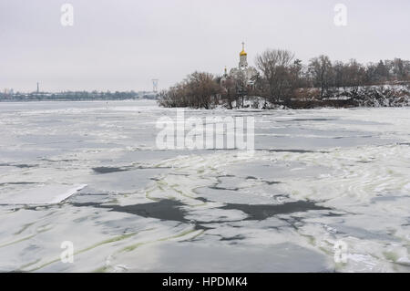 Winterlandschaft mit gefrorenen Fluss Dnepr und orthodoxe Kirche auf Monastyrsky Insel in der Denpr Stadt, Ukraine Stockfoto
