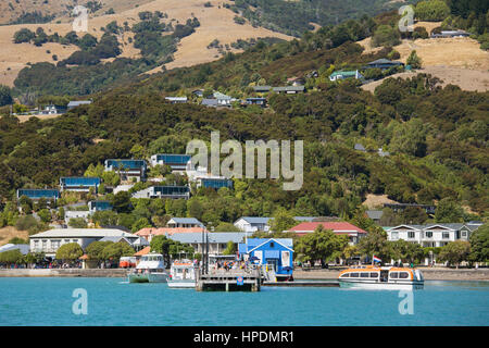 Akaroa, Canterbury, Neuseeland. Blick vom Hafen von Akaroa zu den Häusern am Hang oberhalb der Wharf. Stockfoto