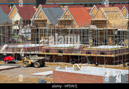 Ein Neubaugebiet Greenfield im Bau, zeigt die Hälfte gebaut Häuser, Kipper-LKW, Generatoren, Gerüste und Baumaschinen Stockfoto