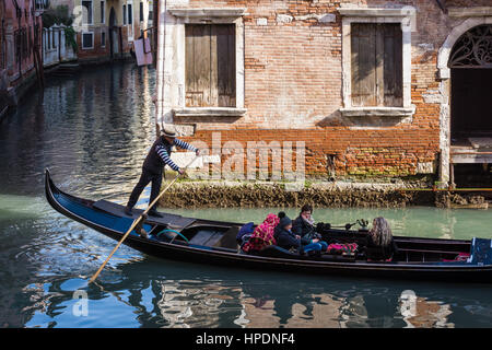 Ein Gondoliere mit traditionellen Hut sieht man Rudern an einem der Kanäle in Venedig Italien Stockfoto