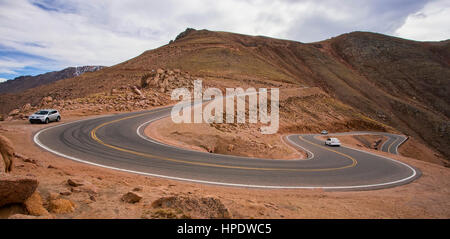 Mehrere Autos klettern die lange, steile, kurvige Straße zum Gipfel des Pikes Peak in Colorado. Stockfoto