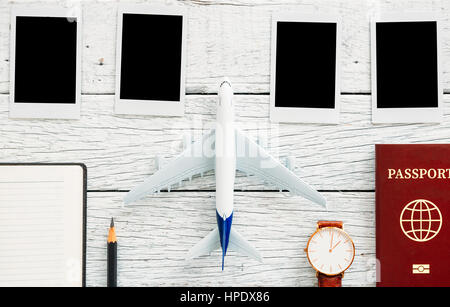 Vorbereitung für die Reise-Konzept, Bleistift, Pass, Flugzeug, Armbanduhr, Fotorahmen, Buch, auf einem weißen Vintage Holz Hintergrund mit Textfreiraum. Stockfoto