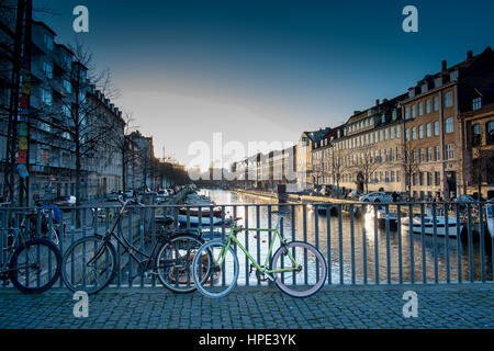 Zyklen über Christianshavn Kanal Copenghagen auf Brücke geparkt. Stockfoto