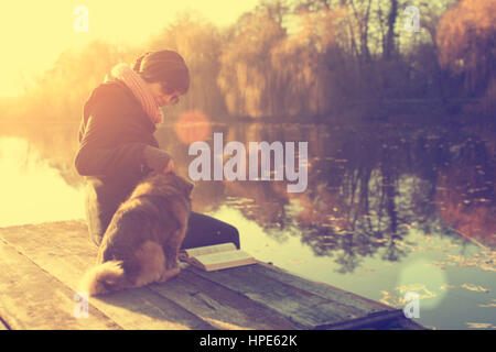 Frau mit Hund im Sonnenuntergang Stockfoto