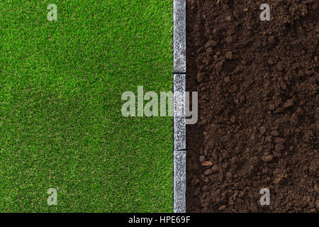 Fruchtbaren Humusboden und üppigen Rasen geteilt durch einen Stein Einfassung, Garten- und Landschaftsbau Konzept Stockfoto