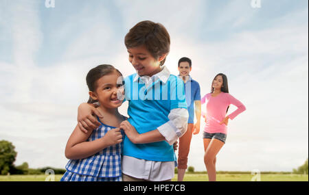 Eltern, die Kinder spielen im Park beobachten Stockfoto