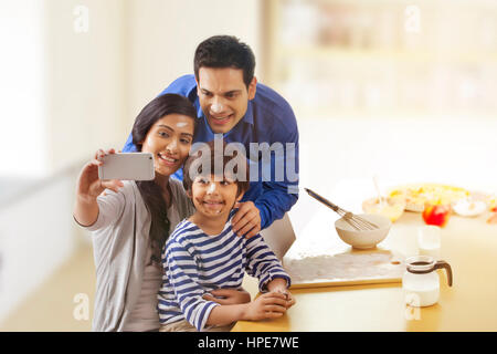 Glückliche Familie nehmen Selfie während des Backens in Küche Stockfoto