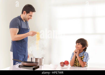 Vater und Sohn Kochen Nudeln in der Küche Stockfoto