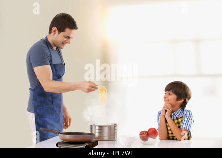 Vater und Sohn, die Nudeln in der Küche vorbereiten Stockfoto