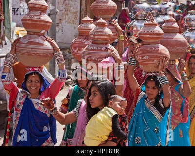 Frauen tragen symbolische Schalen auf ihren Köpfen in einer Prozession, der seinen Weg durch die Straßen von Deogarh in Rajasthan im Rahmen der Hochzeitsfeier Stockfoto