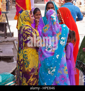 Frauen in typisch bunten Rajasthani kleiden sich im hart umkämpften Marktbereich Deogarh Stadt engagiert im Gespräch Stockfoto