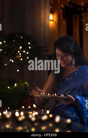 Frau, die Vermittlung von irdenen Lampen an diwali Stockfoto